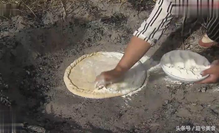 把大饼贴在火炉里面烤熟,把饼放在烤炉里面烤