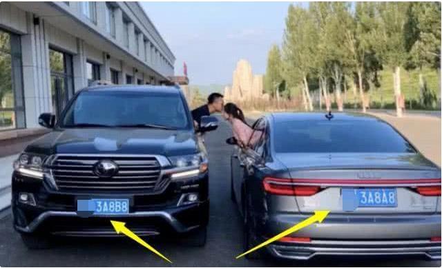 年轻小夫妻秀恩爱，车牌都是情侣号，身后车标是亮点