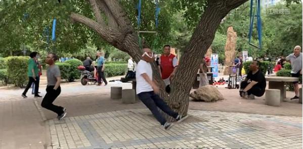 一老人上吊式练颈椎,老太太头吊在树上治颈椎病