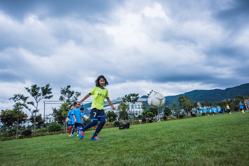 开学上学校踢球,春天到了小朋友们在草地上踢足球
