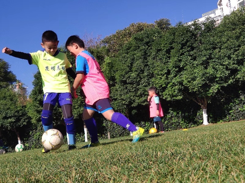 开学上学校踢球,春天到了小朋友们在草地上踢足球