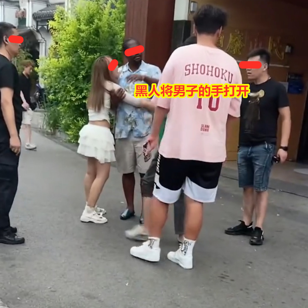 女子移情黑人男子，男友上前想将二人分开，女子哭着抱紧不肯松手