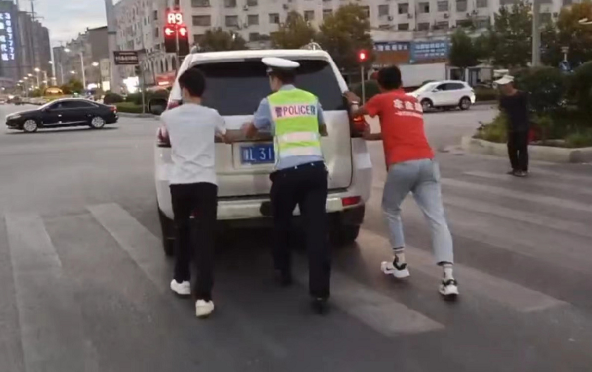 车辆暴雨中抛锚交警帮忙推车,越野车救助抛锚警车